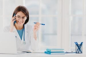 Glad professional doctor concentrated in modern laptop