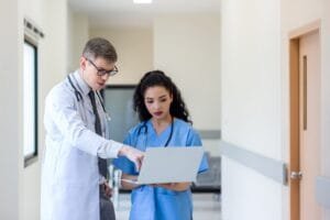 Doctor using laptop computer at hospital.