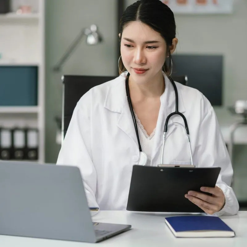 doctor-working-on-laptop-computer-and-tablet-and-medical-stethoscope-on-clipboard-on-desk.jpg